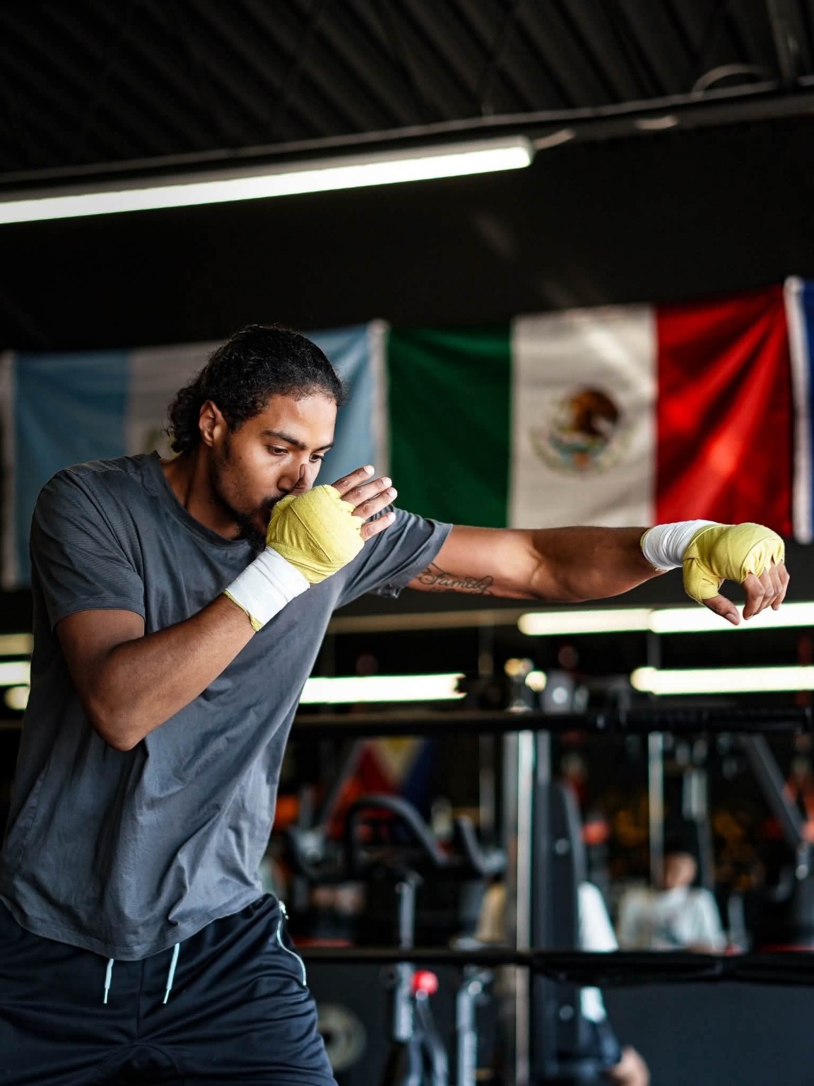 A boxer shadowboxes with wrapped hands, working on stance and punch extension