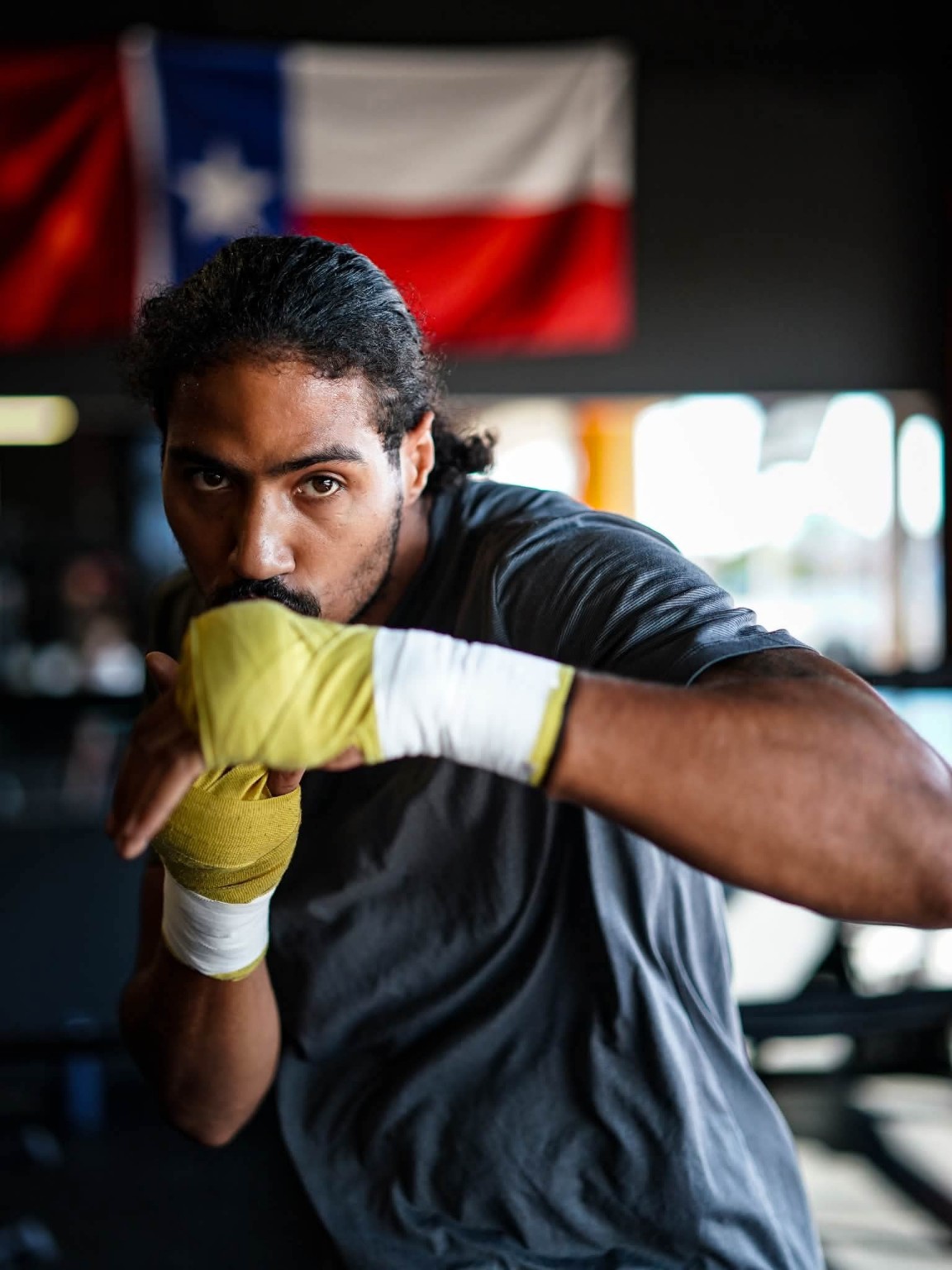A boxer holds a tight guard with wrapped hands during fundamentals training at PunchTown