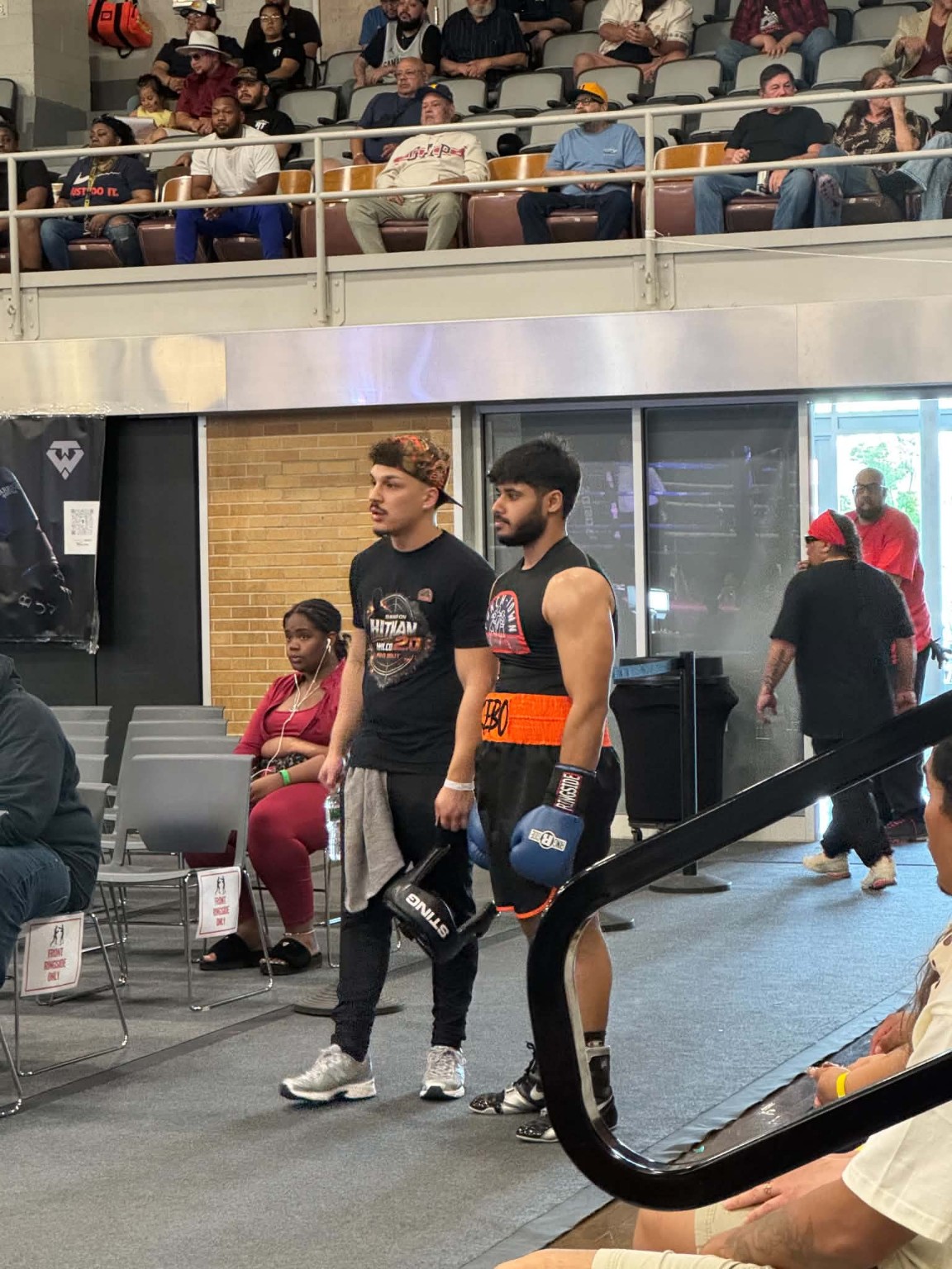 Amateur boxing competitors arriving and preparing near the ring on competition day