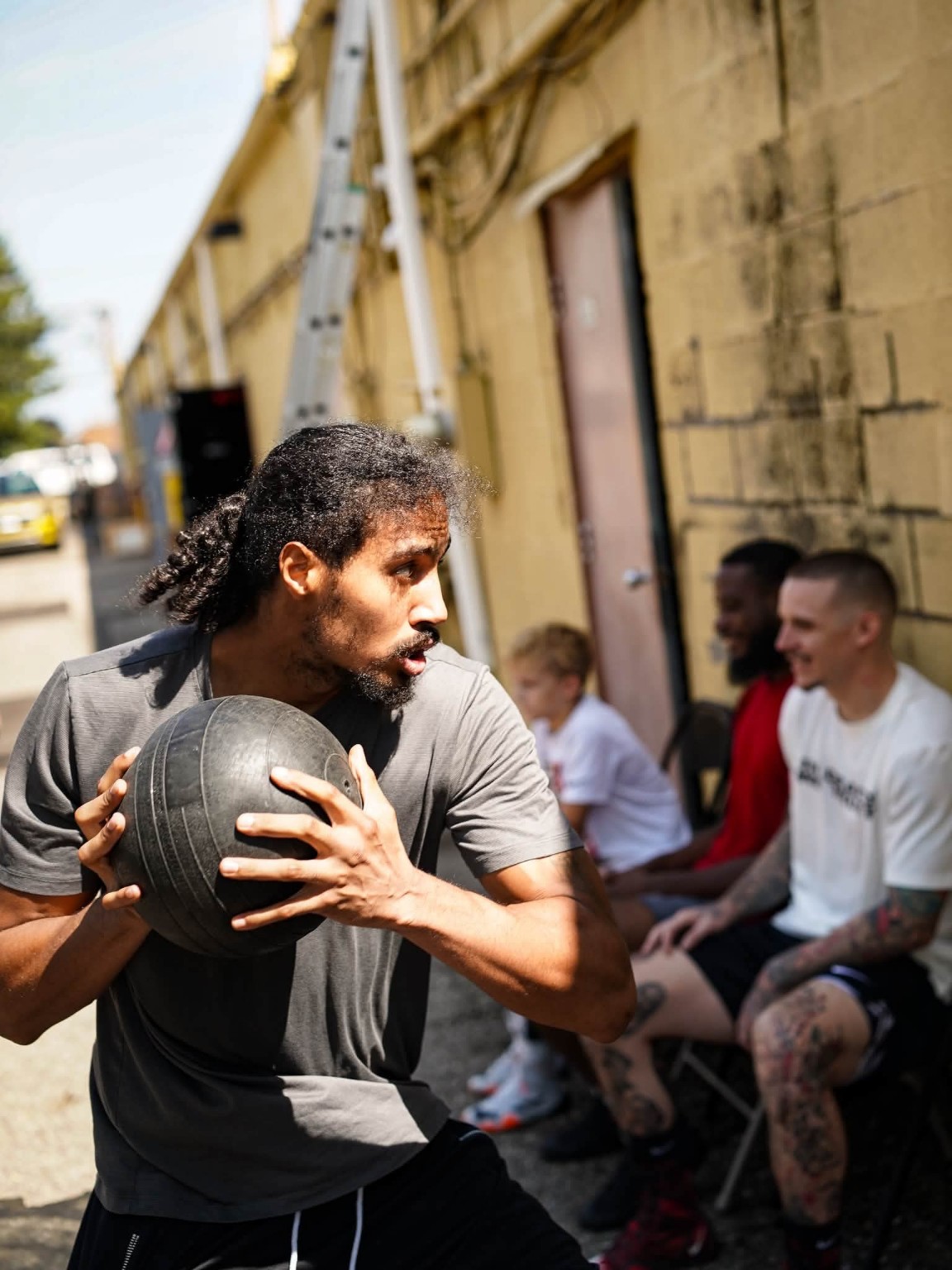 A boxer runs through a medicine ball conditioning drill outside the gym