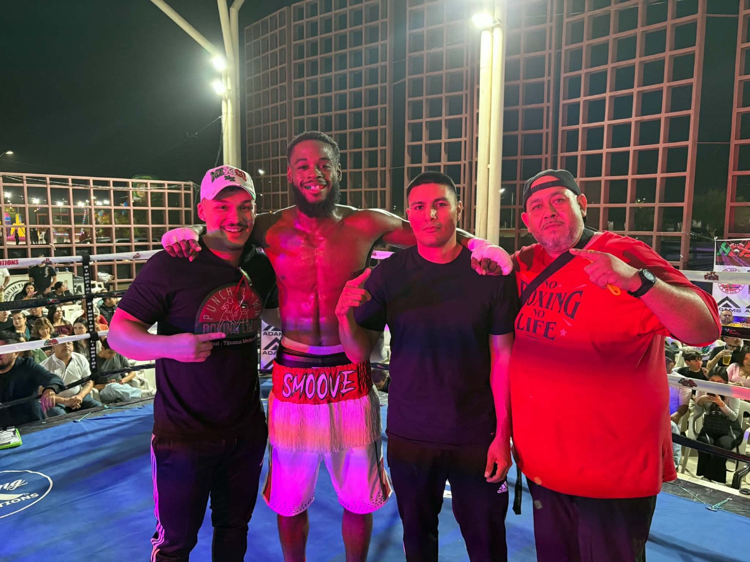 Bryant “Too Smoove” Brown with his team celebrating in the ring under the lights