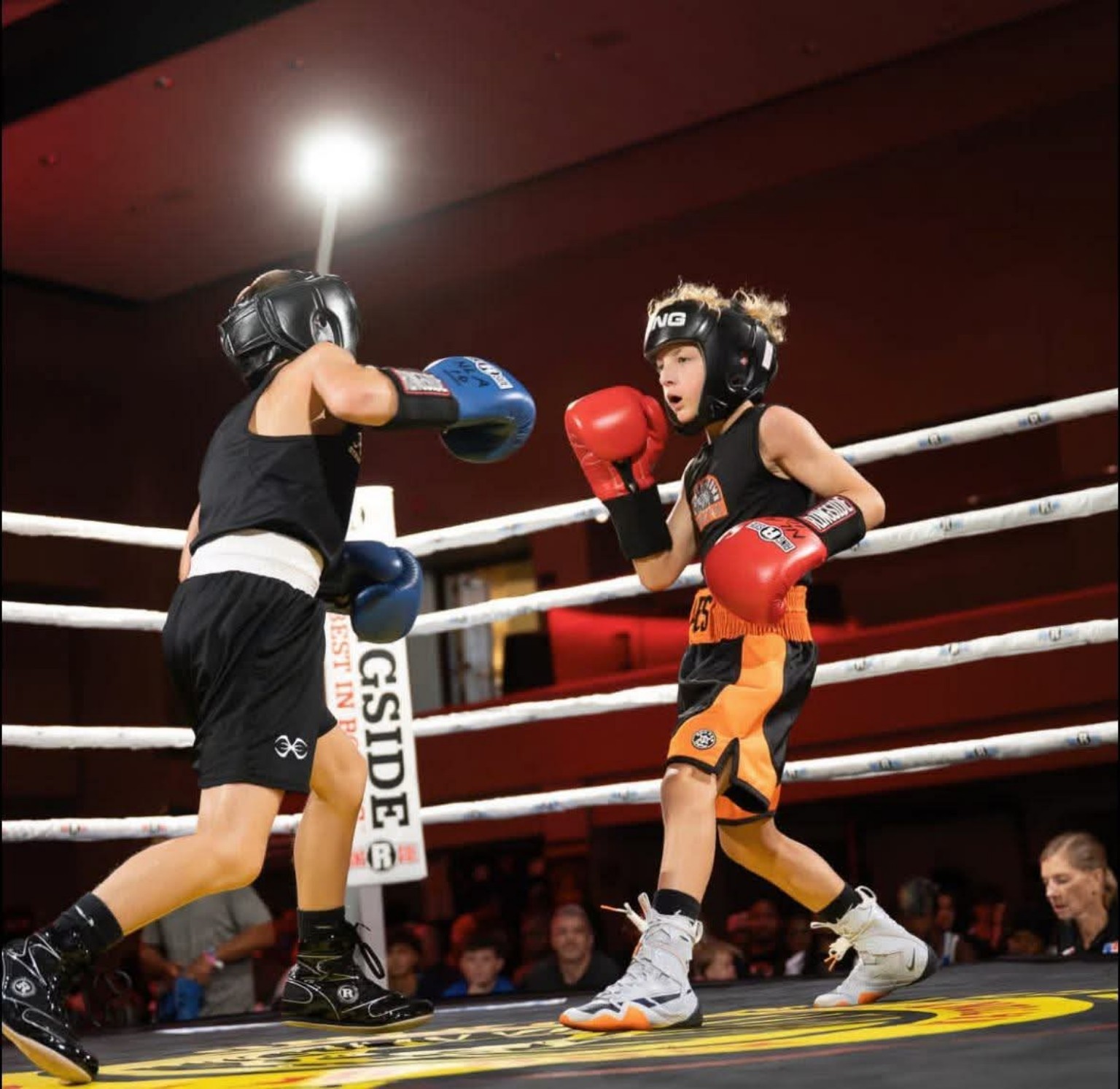 Two young amateur boxers exchange punches during a match