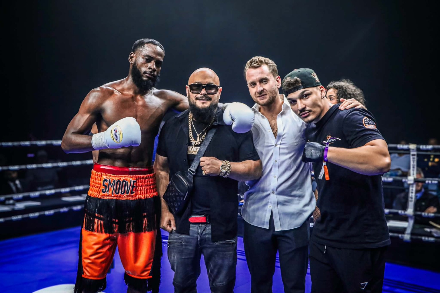 Bryant “Too Smoove” Brown posing in the ring with his team after a fight