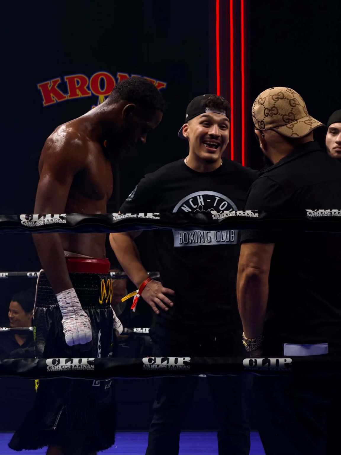 A boxer and his team talking together in the ring on fight night